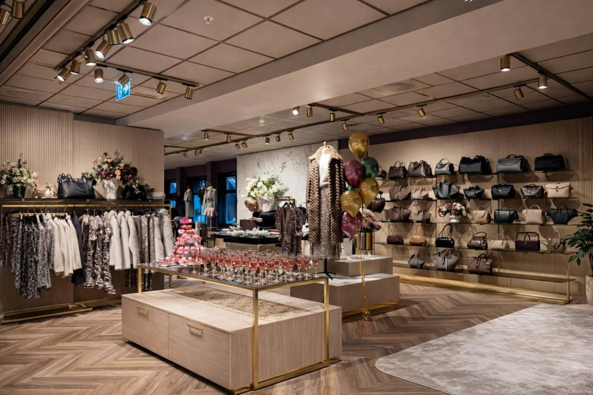 Ferdig montert butikkinnredning hos Follestad Trend med disker, hyller og klesstativ i lyst tre