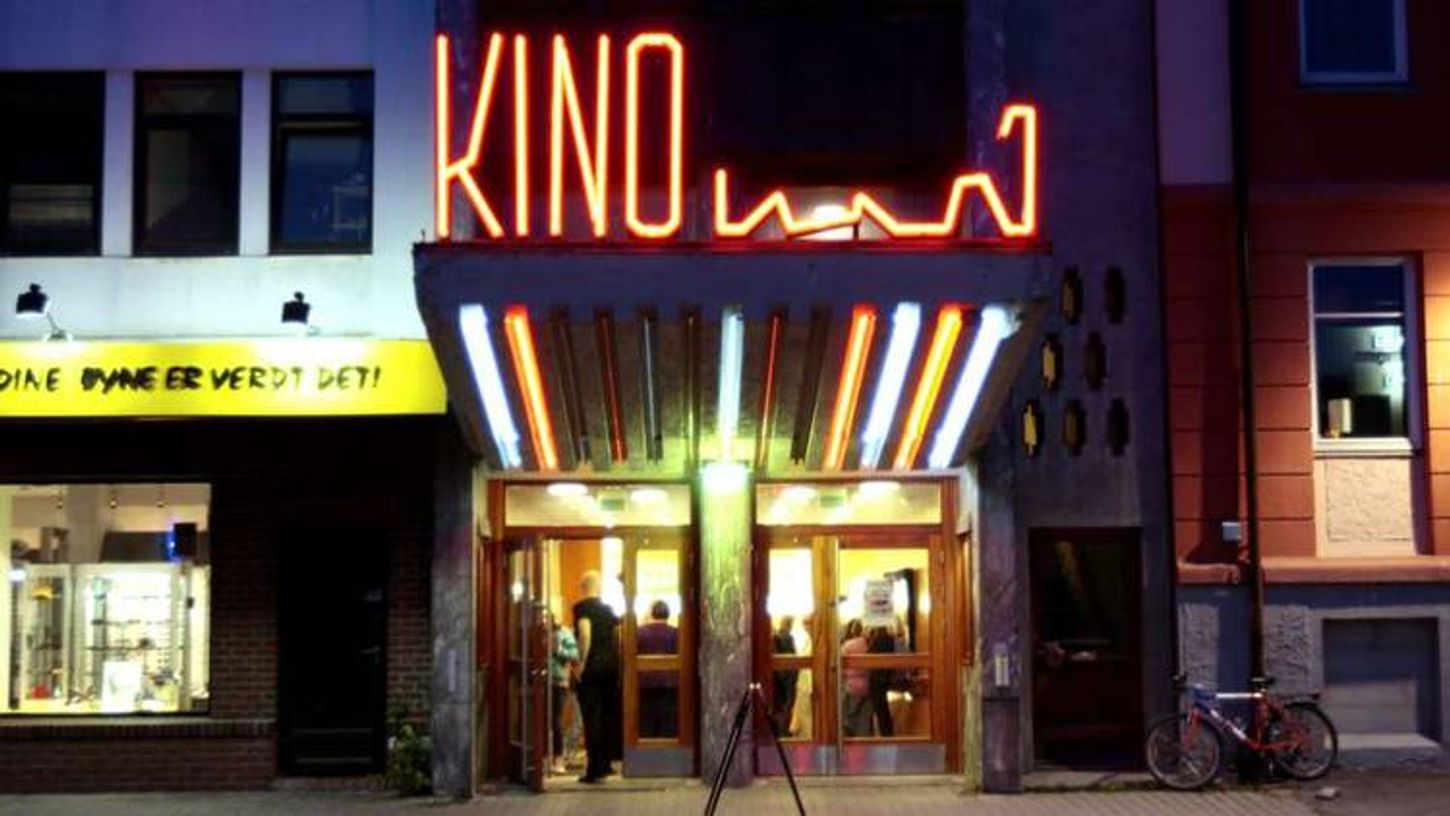 Inngangen til Harstad kino med opplyst KINO-skilt i neon