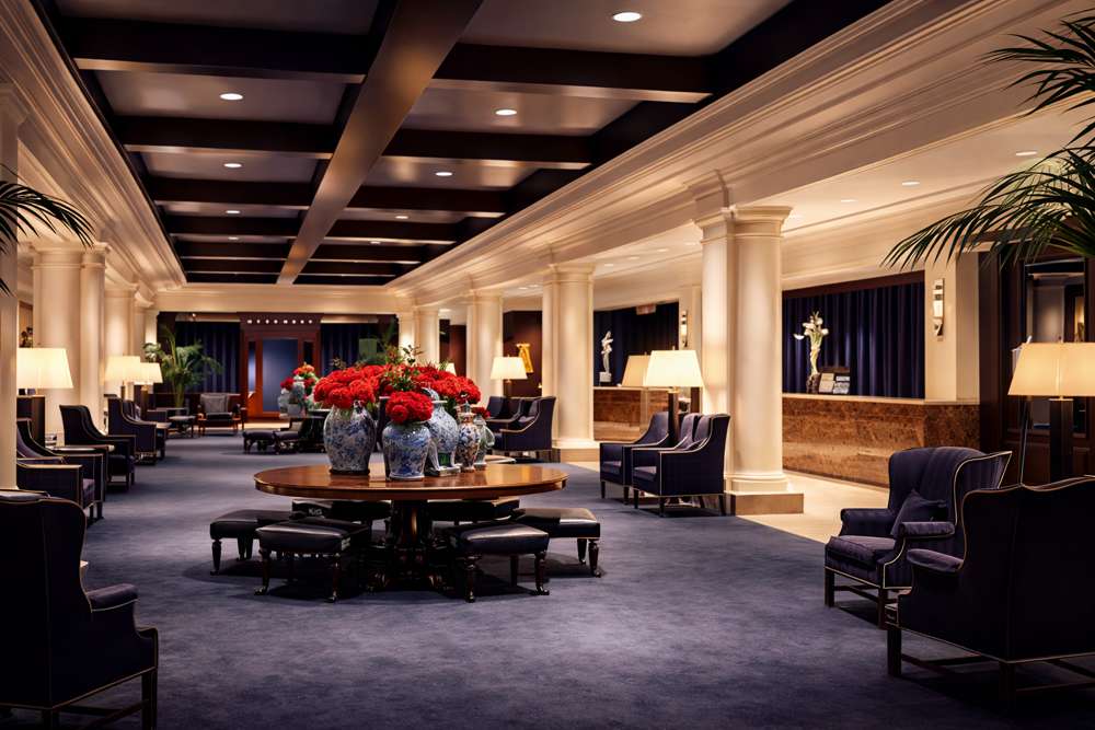 Hotellobby med resepsjon, sittegrupper og rundt bord med blomster